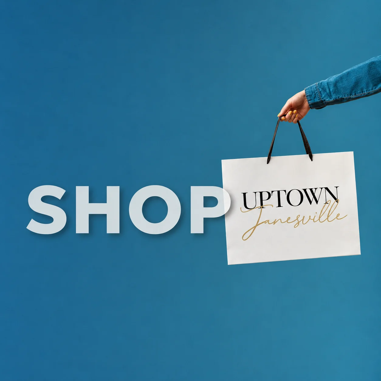 Shop Uptown Janesville: a hand holding an Uptown Janesville shopping bag